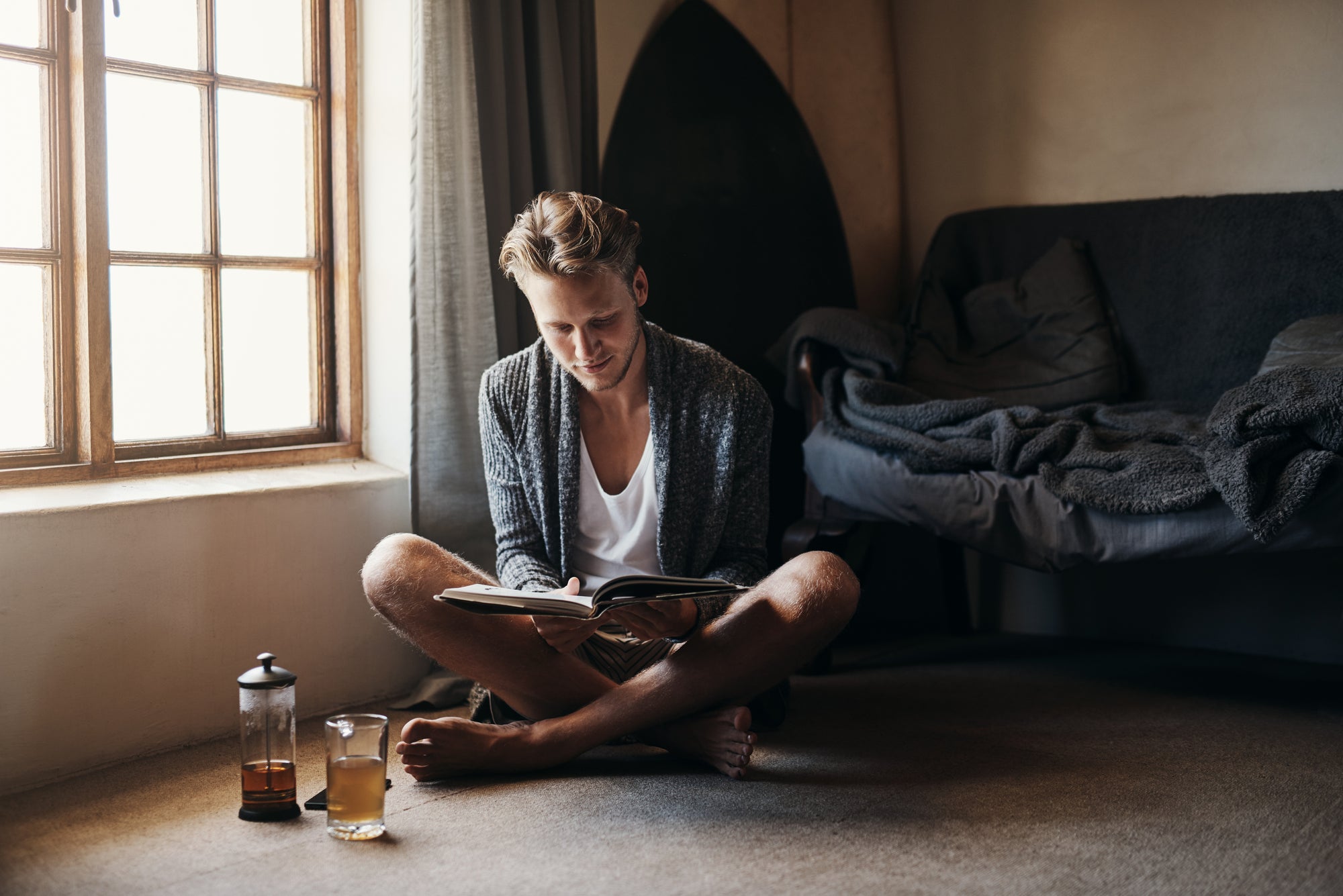 Een man die zich terug trekt naar een veilige plek met een kop warme kamillethee en een goed boek